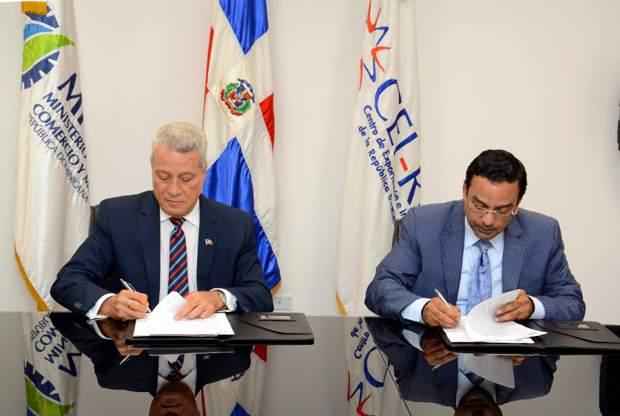 Titular del MICM, Nelson Toca Simó y Marius de León Pérez, director del CEI-RD, durante la firma del pacto mediante el cual se crea el centro especializado en exportación para las mipymes.