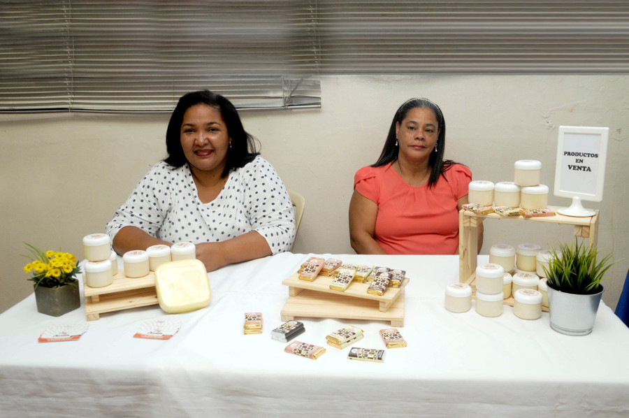 Nelfi García y una colaboradora de Chocolala, presentan algunos de los productos que fabrica la empresa.
