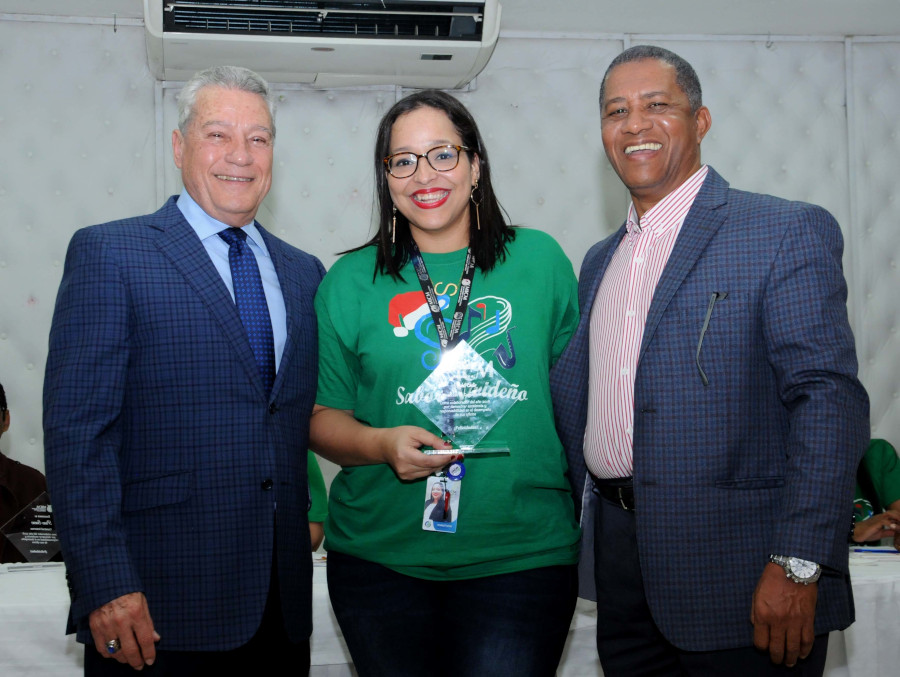 Titular del MICM, Nelson Toca Simó, y el director de Comunicaciones, Manuel Jiménez, entregan reconocimiento a Scarlet Ortiz, de Comunicaciones por su alto desempeño.