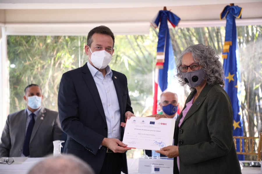 Ministro Bisonó durante la entrega de los certificados a una de las participantes del diplomado.    